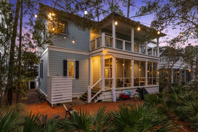 back house at dusk featuring a balcony