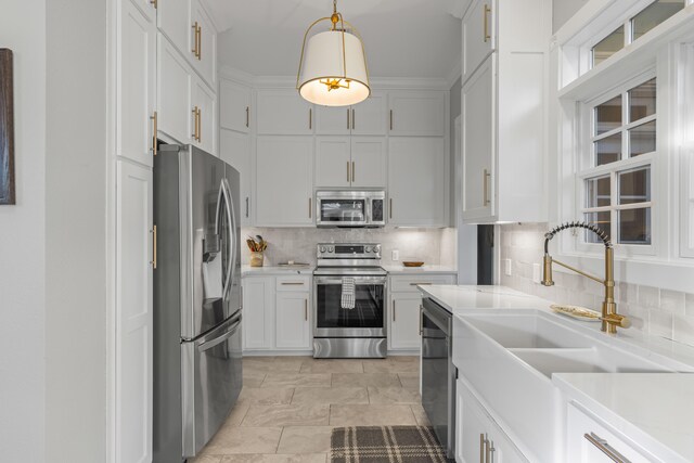 kitchen featuring sink, hanging light fixtures, decorative backsplash, white cabinetry, and stainless steel appliances