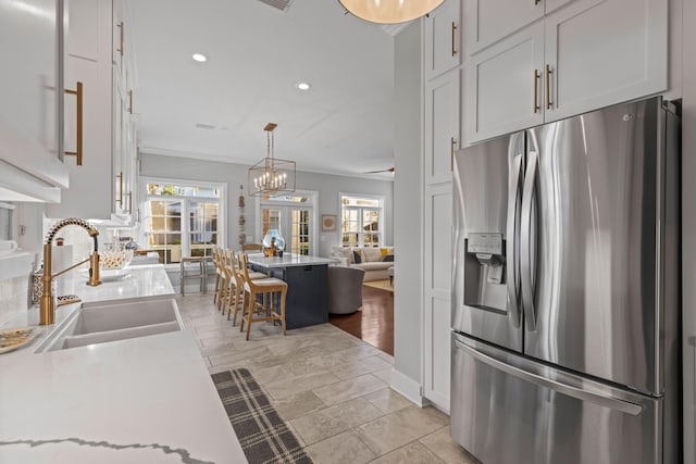 kitchen featuring white cabinets, stainless steel refrigerator with ice dispenser, french doors, and a wealth of natural light