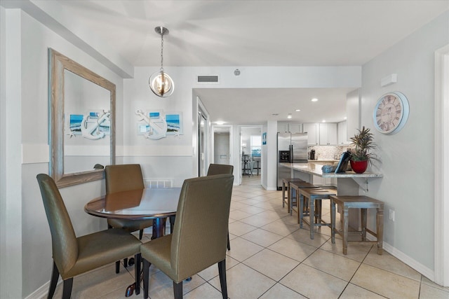 dining area featuring light tile patterned flooring and a notable chandelier