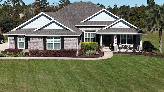 624 Tournament Ln, Freeport, FL 32439 - view of front of house featuring a front lawn, a shingled roof, covered porch, and brick siding