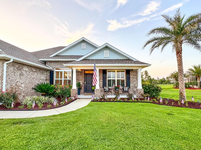 624 Tournament Ln, Freeport, FL 32439 - craftsman inspired home with brick siding, a yard, a porch, and roof with shingles