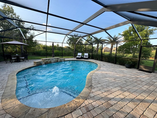 view of swimming pool featuring pool water feature, glass enclosure, and a patio