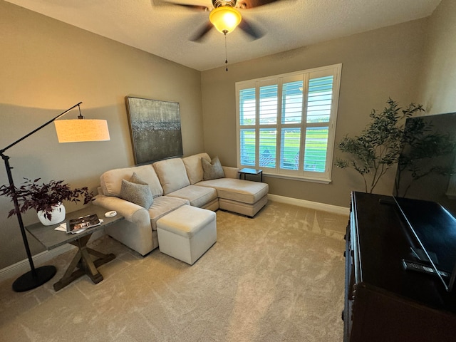 carpeted living room featuring ceiling fan and a textured ceiling