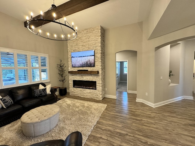 624 Tournament Ln, Freeport, FL 32439 - living area featuring arched walkways, high vaulted ceiling, a fireplace, wood finished floors, and a chandelier