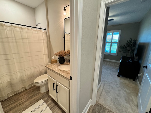 bathroom featuring hardwood / wood-style floors, vanity, a textured ceiling, and toilet