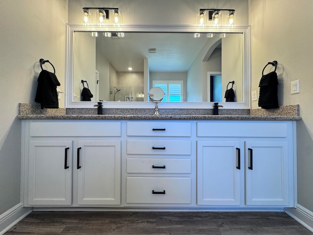 bathroom with a shower with door, vanity, and hardwood / wood-style floors