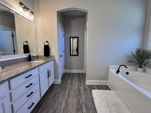 624 Tournament Ln, Freeport, FL 32439 - bathroom featuring vanity, wood finished floors, a bath, and baseboards
