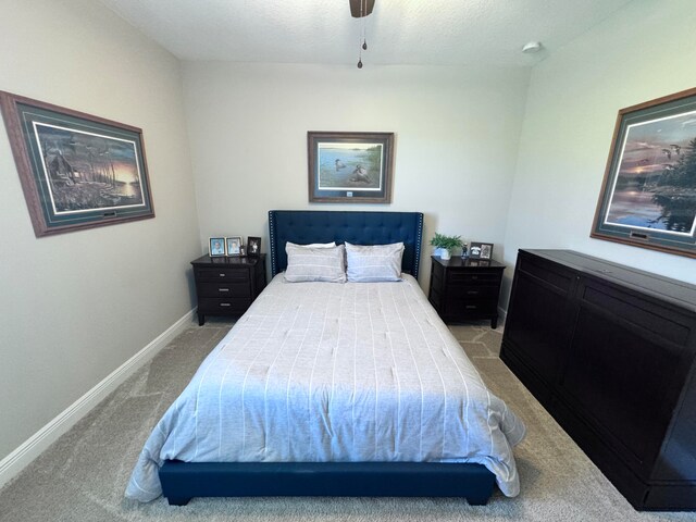 bedroom with a textured ceiling, light colored carpet, and ceiling fan