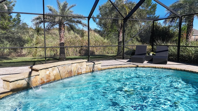 view of swimming pool featuring glass enclosure and pool water feature