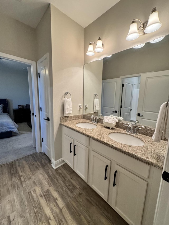 624 Tournament Ln, Freeport, FL 32439 - full bathroom with double vanity, wood finished floors, and ensuite bathroom