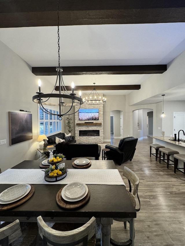 624 Tournament Ln, Freeport, FL 32439 - dining area featuring a chandelier, arched walkways, wood finished floors, beam ceiling, and baseboards