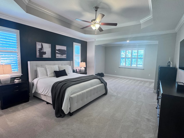 carpeted bedroom featuring a raised ceiling, ceiling fan, and crown molding