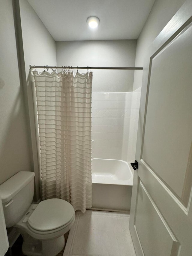 bathroom featuring shower / tub combo and toilet