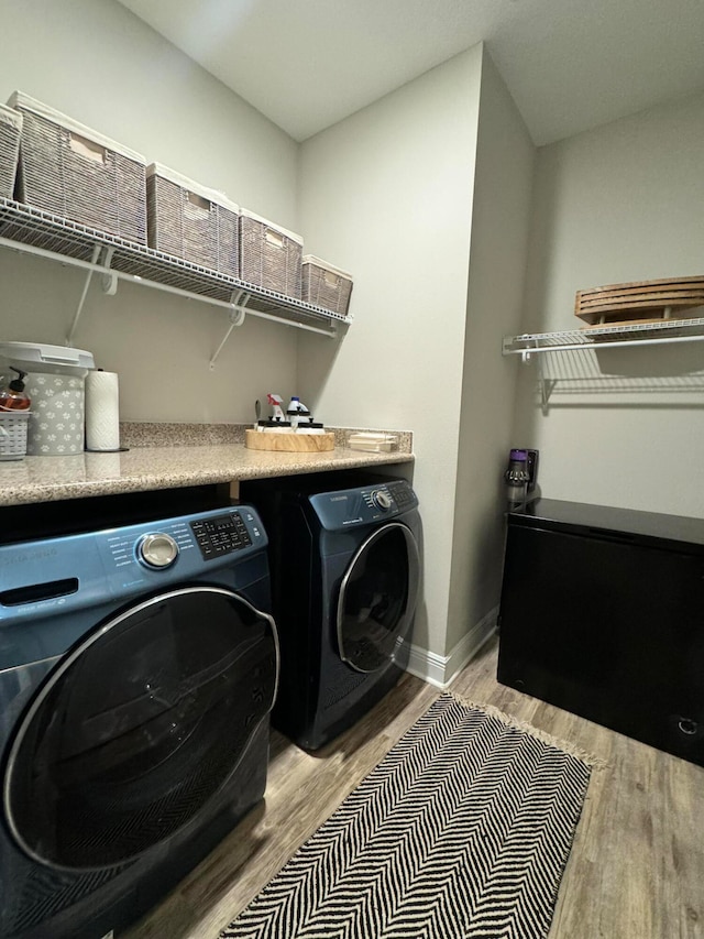 washroom with independent washer and dryer and light hardwood / wood-style flooring