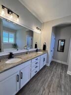 624 Tournament Ln, Freeport, FL 32439 - full bathroom with wood finished floors, double vanity, a garden tub, and baseboards