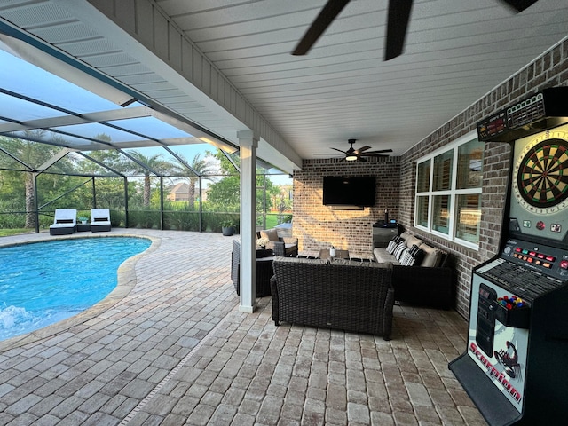 view of swimming pool with outdoor lounge area, ceiling fan, a patio area, and a lanai