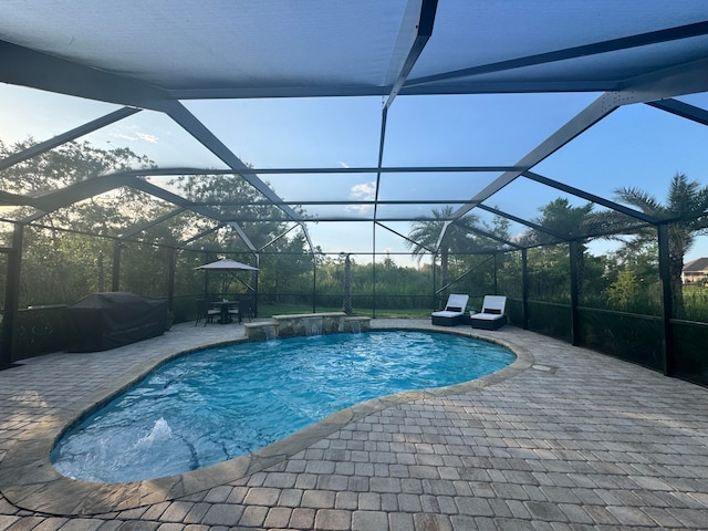 view of swimming pool featuring pool water feature, a lanai, and a patio area