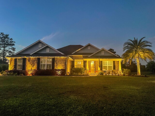 624 Tournament Ln, Freeport, FL 32439 - craftsman-style home with a front lawn, covered porch, and brick siding