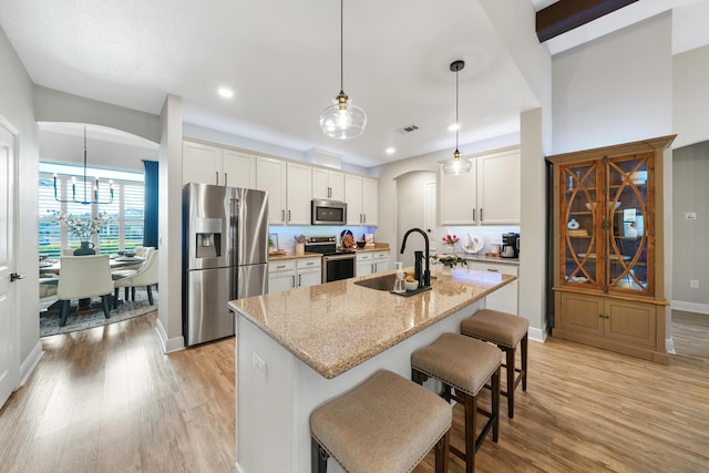 624 Tournament Ln, Freeport, FL 32439 - kitchen featuring appliances with stainless steel finishes, a sink, arched walkways, light wood-style flooring, and recessed lighting