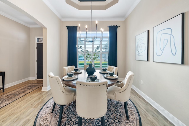624 Tournament Ln, Freeport, FL 32439 - dining room with a chandelier, light wood-style floors, crown molding, baseboards, and arched walkways