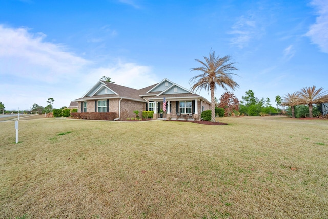 624 Tournament Ln, Freeport, FL 32439 - view of front facade with a front yard, brick siding, and a porch