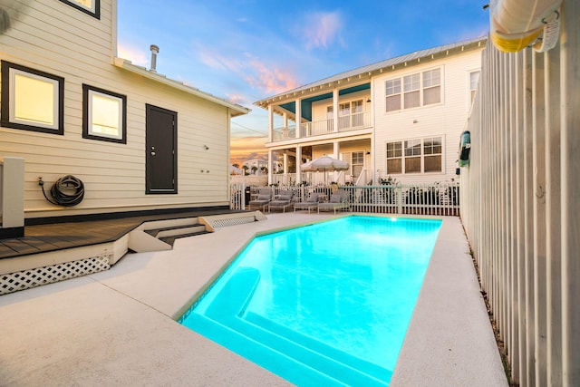 pool at dusk with a wooden deck