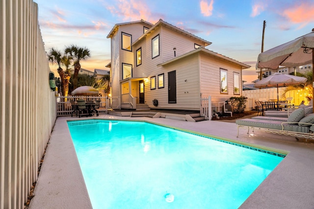 pool at dusk featuring a wooden deck