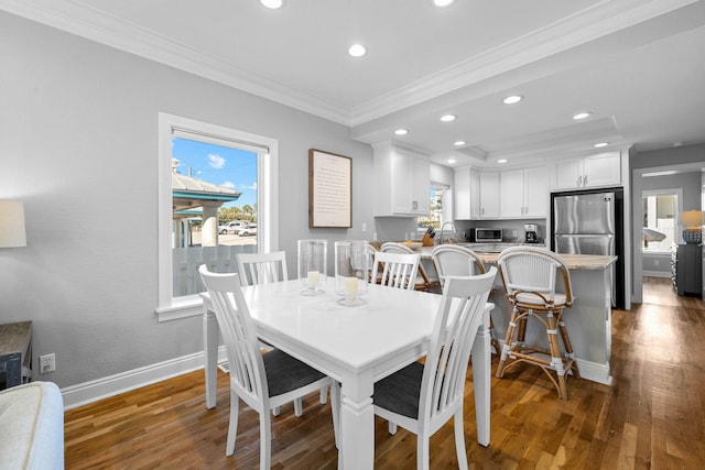 dining room with dark hardwood / wood-style floors, ornamental molding, and sink