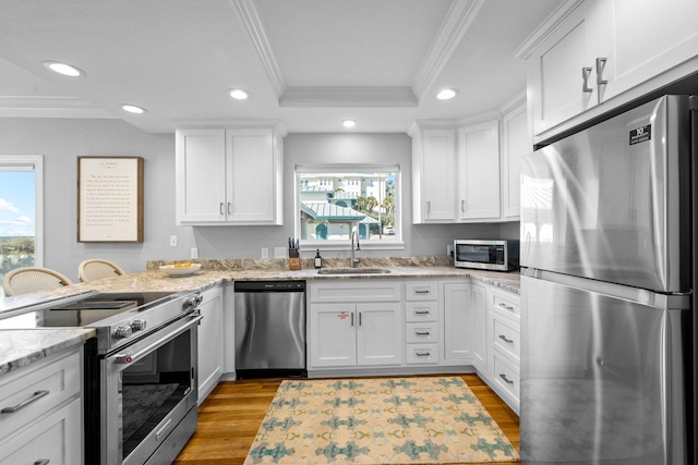 kitchen featuring light stone countertops, appliances with stainless steel finishes, sink, light hardwood / wood-style flooring, and white cabinetry