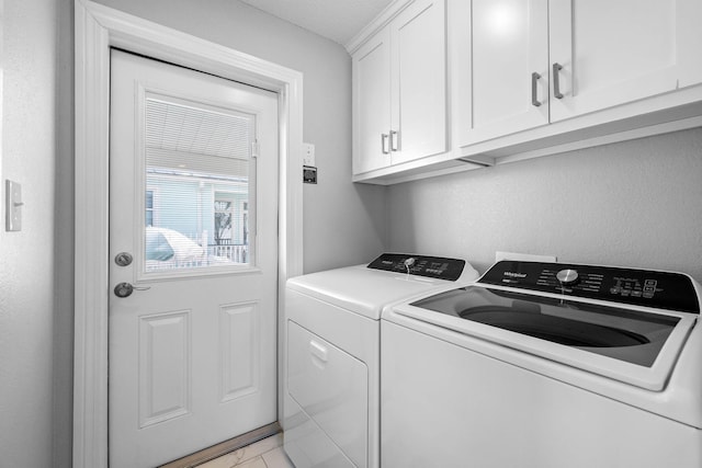 washroom with washer and clothes dryer and cabinets