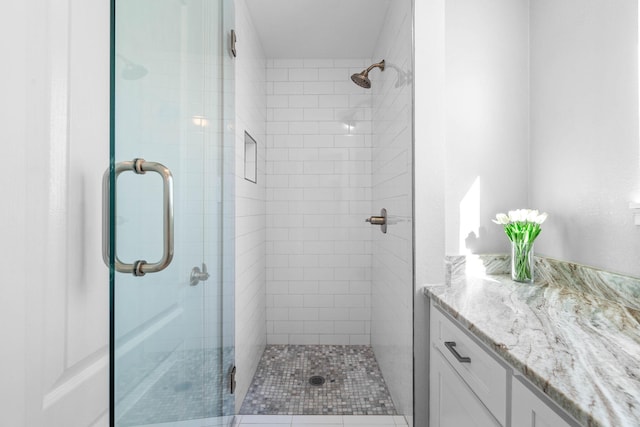 bathroom featuring a shower with door, vanity, and tile patterned flooring