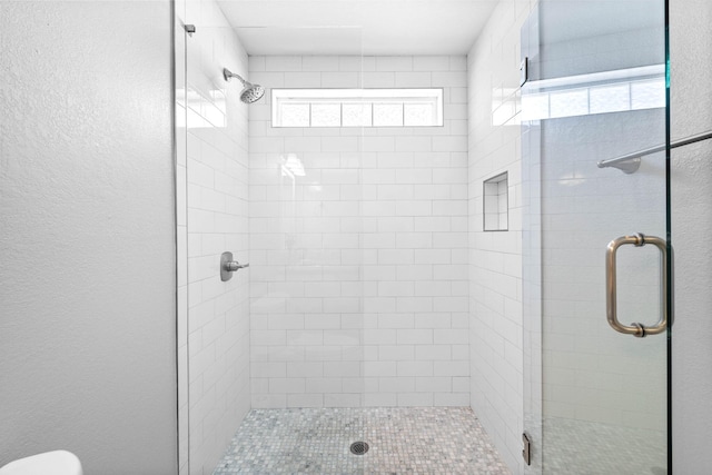 bathroom featuring toilet and an enclosed shower