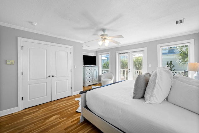 bedroom featuring access to exterior, french doors, ornamental molding, ceiling fan, and hardwood / wood-style flooring