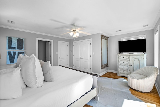 bedroom with hardwood / wood-style floors, ceiling fan, and crown molding