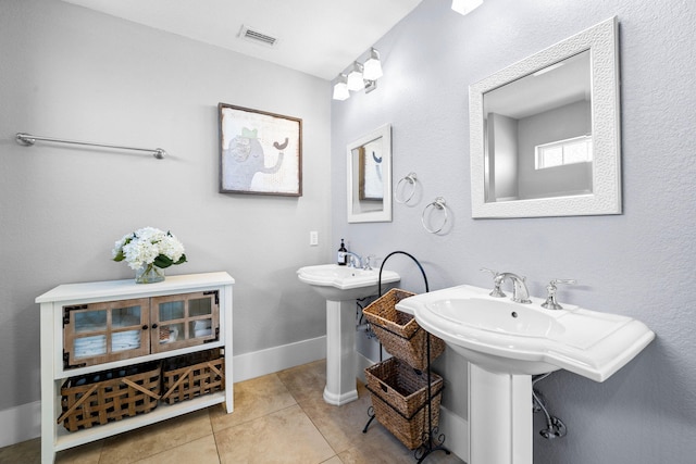 bathroom with tile patterned floors and dual sinks