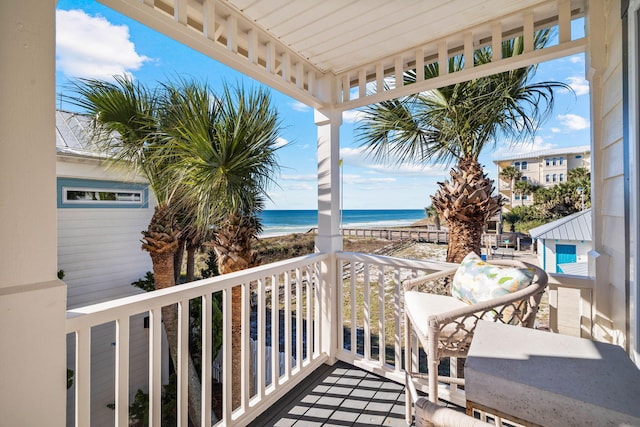 balcony featuring a water view and a view of the beach