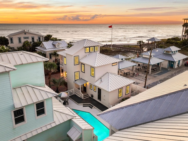 aerial view at dusk featuring a water view