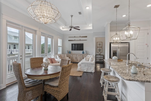 dining room with french doors, ceiling fan with notable chandelier, a tray ceiling, dark wood-type flooring, and sink