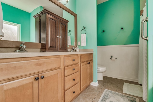 bathroom with tile patterned flooring, vanity, and toilet