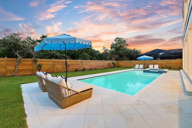 pool at dusk featuring an in ground hot tub, a yard, and a patio