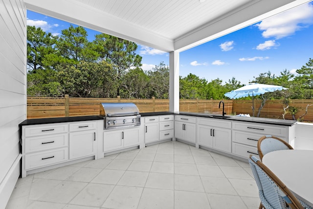 view of patio with area for grilling, a grill, and sink