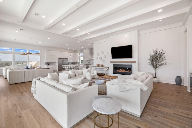 living room with light hardwood / wood-style floors and beam ceiling