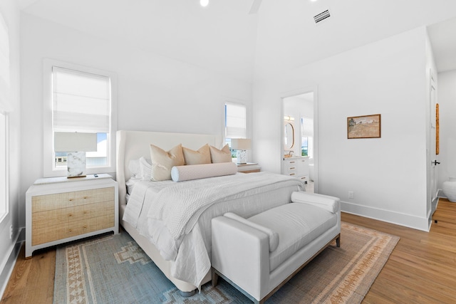 bedroom with wood-type flooring and connected bathroom