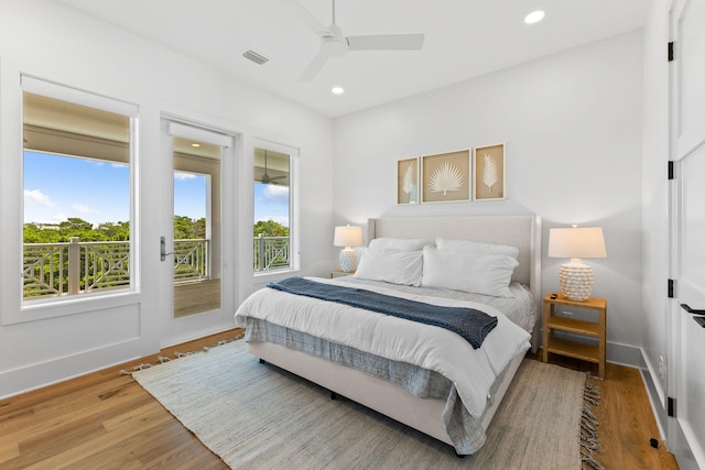 bedroom featuring access to exterior, ceiling fan, hardwood / wood-style floors, and multiple windows