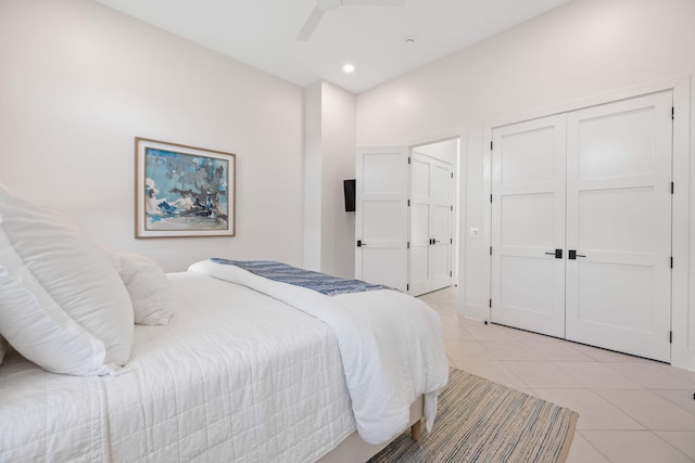 tiled bedroom with ceiling fan and a closet