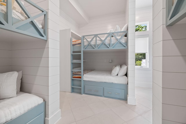 bedroom featuring multiple windows, wood walls, and crown molding