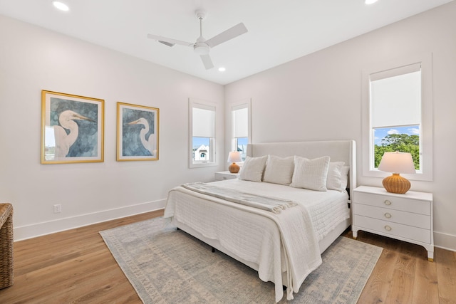 bedroom featuring multiple windows, ceiling fan, and hardwood / wood-style floors