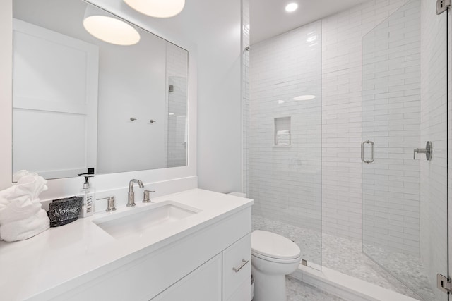 bathroom featuring toilet, vanity, and walk in shower