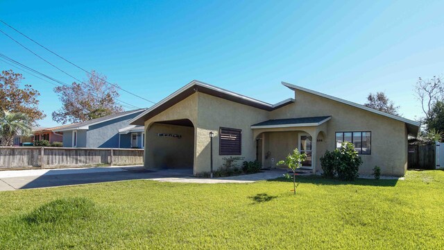 ranch-style home featuring a garage and a front lawn